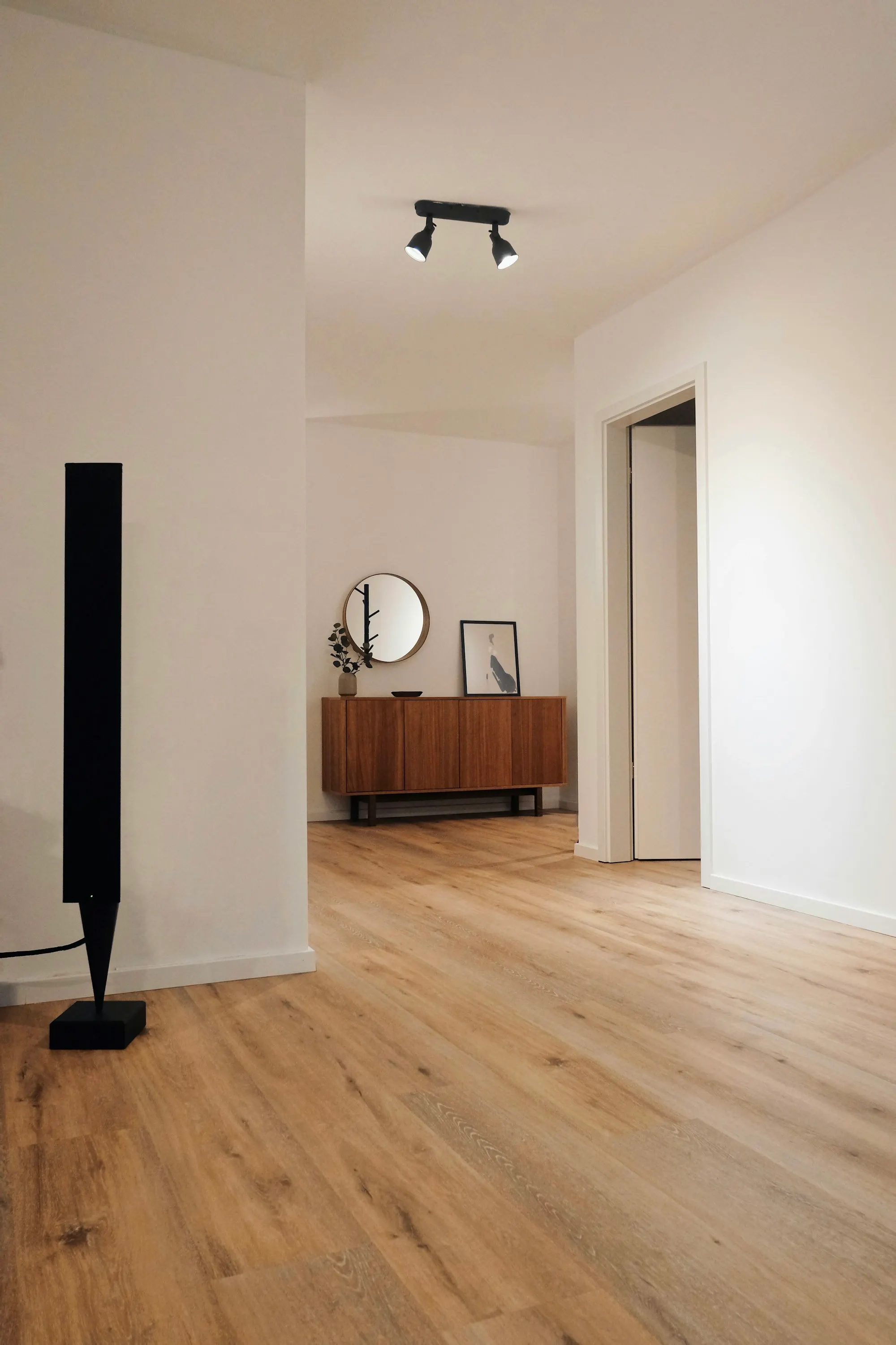 Hallway with new oak flooring, a console table and round mirror