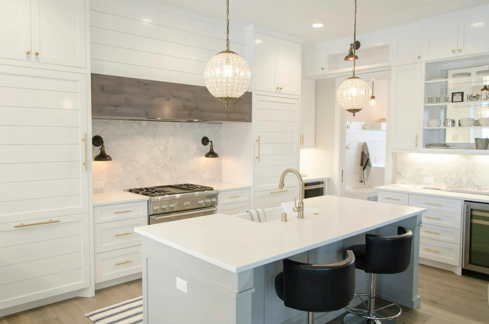 White shaker kitchen with a marble-look island and pendant lights