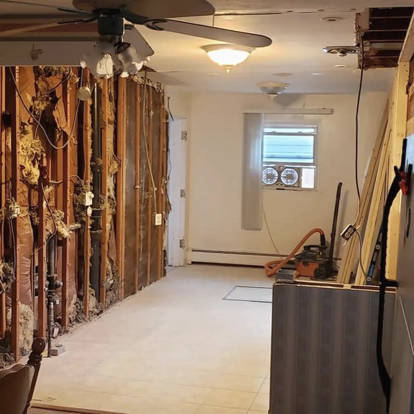 Demo day: kitchen stripped to the studs with the floor exposed