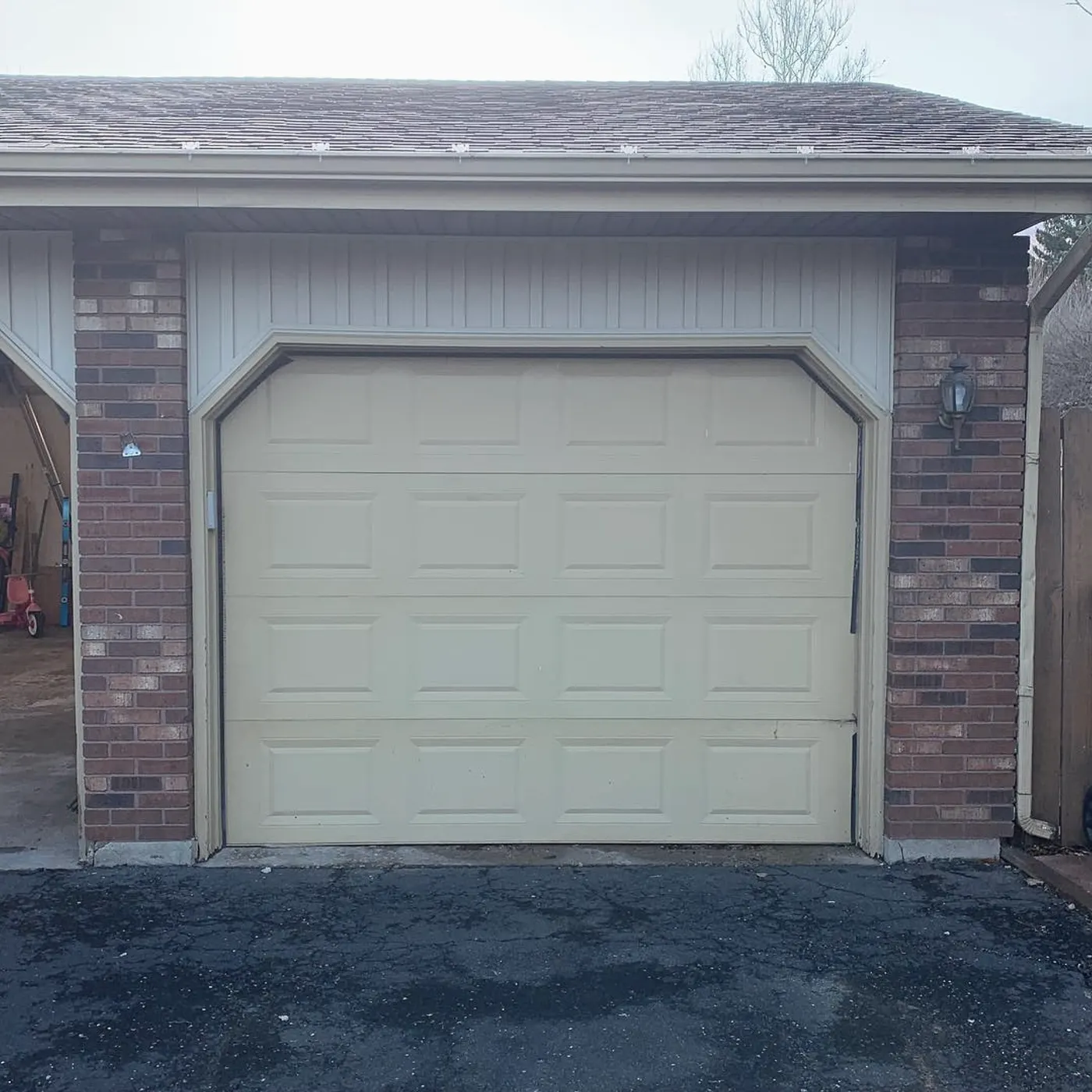 Brick garage with a newly installed white garage door