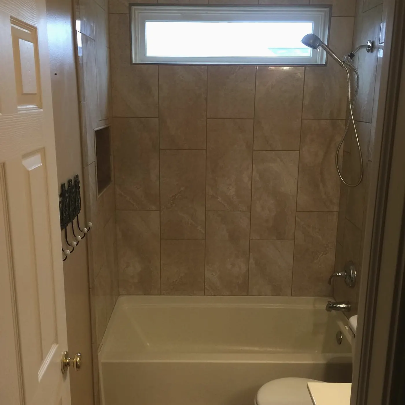 Tiled tub and shower surround with a window and a new shower fixture