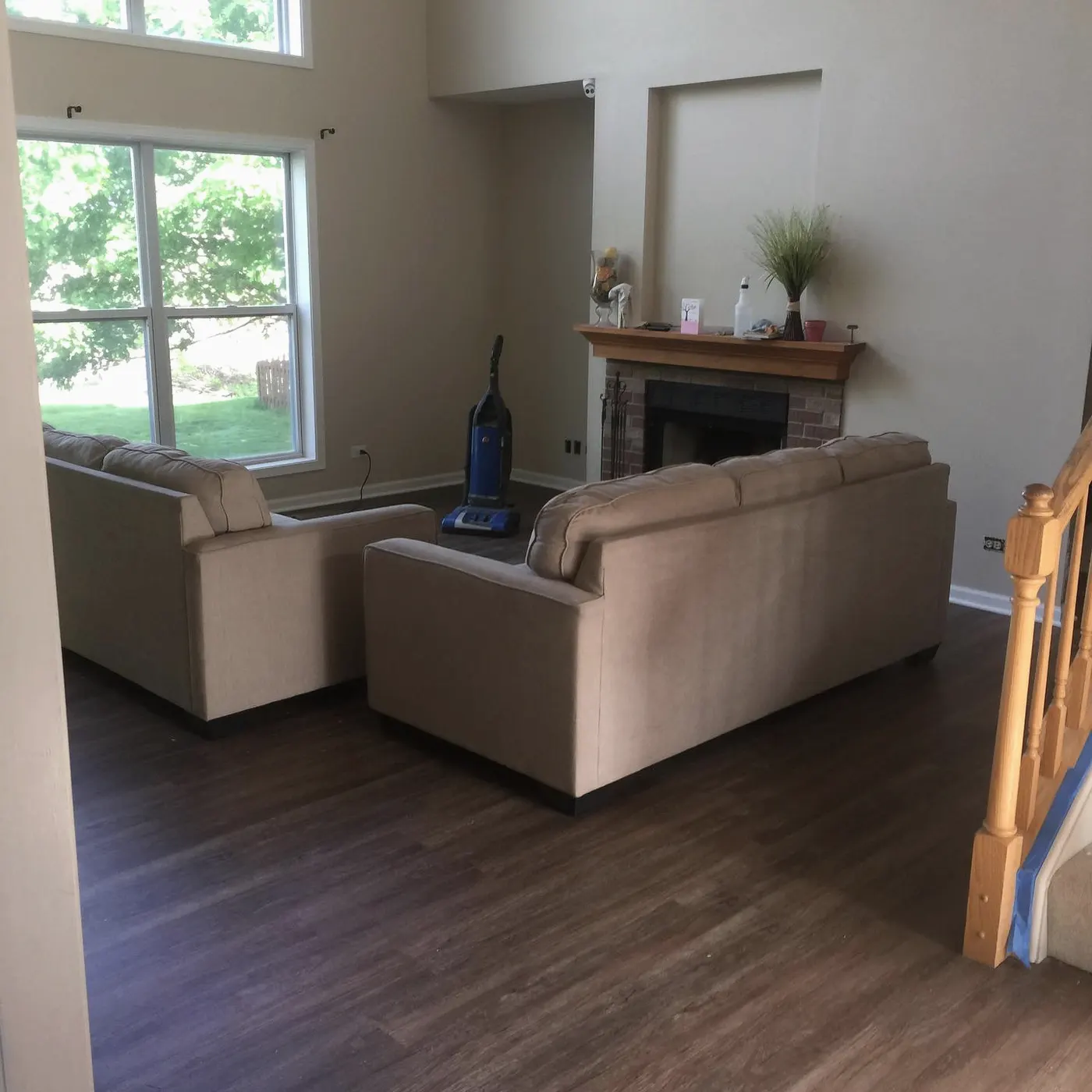 Living room with new wood-look plank floors and a two-storey window