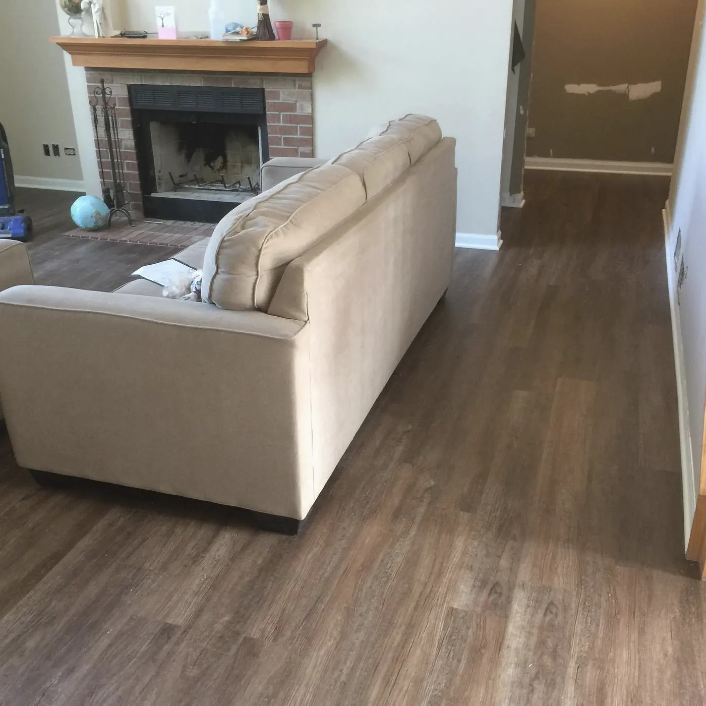 Living room with new plank flooring and a brick fireplace