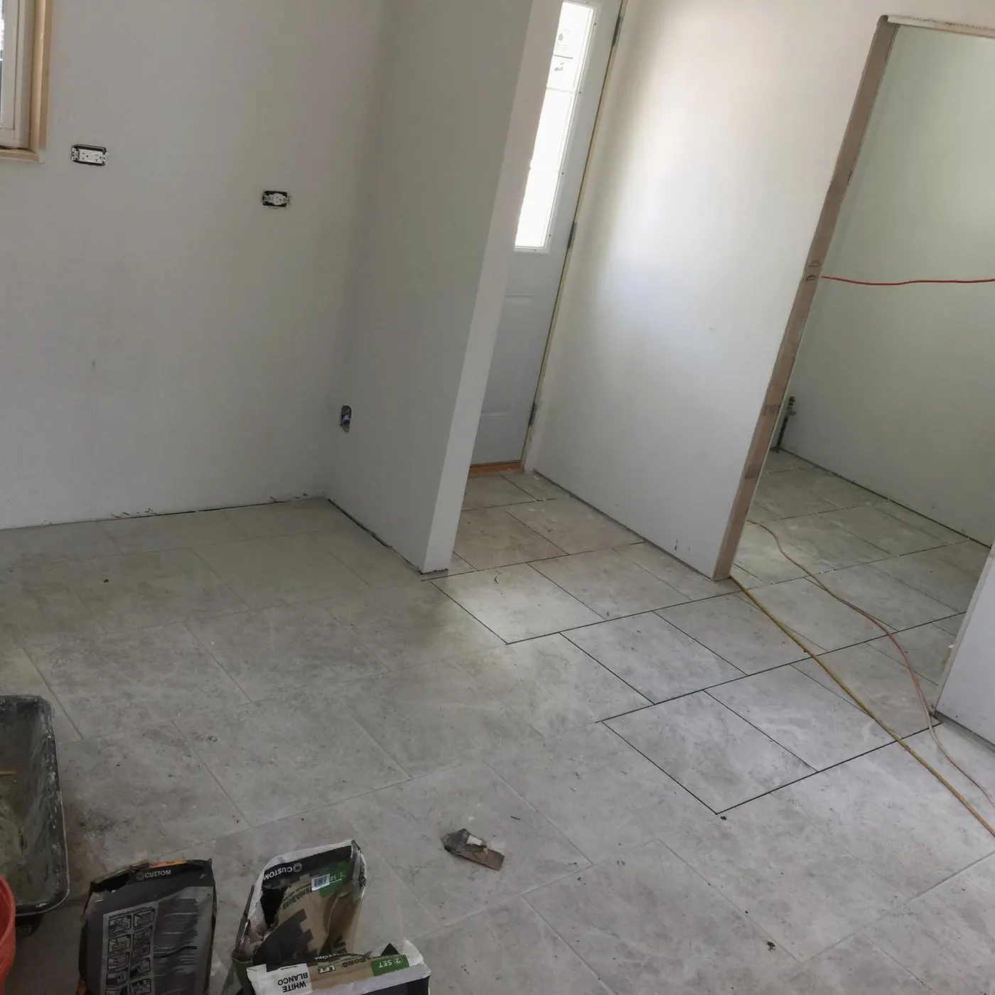 Hallway with new tile floor and a freshly hung interior door
