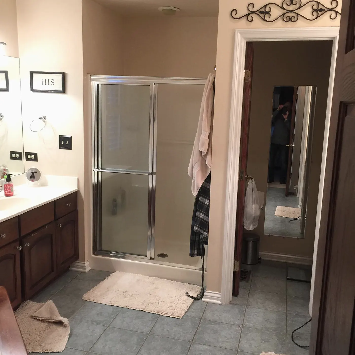 Before: master bathroom with a framed glass shower, dark wood vanity and almond tile floor